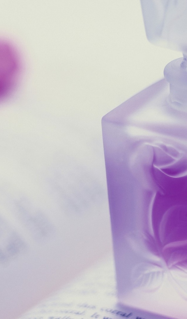 Флакон духов на открытой книге