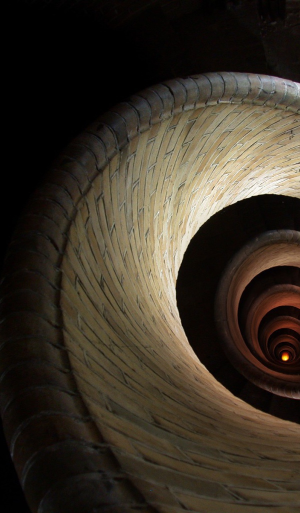 Спираль винтовой лестницы уходит вглубь