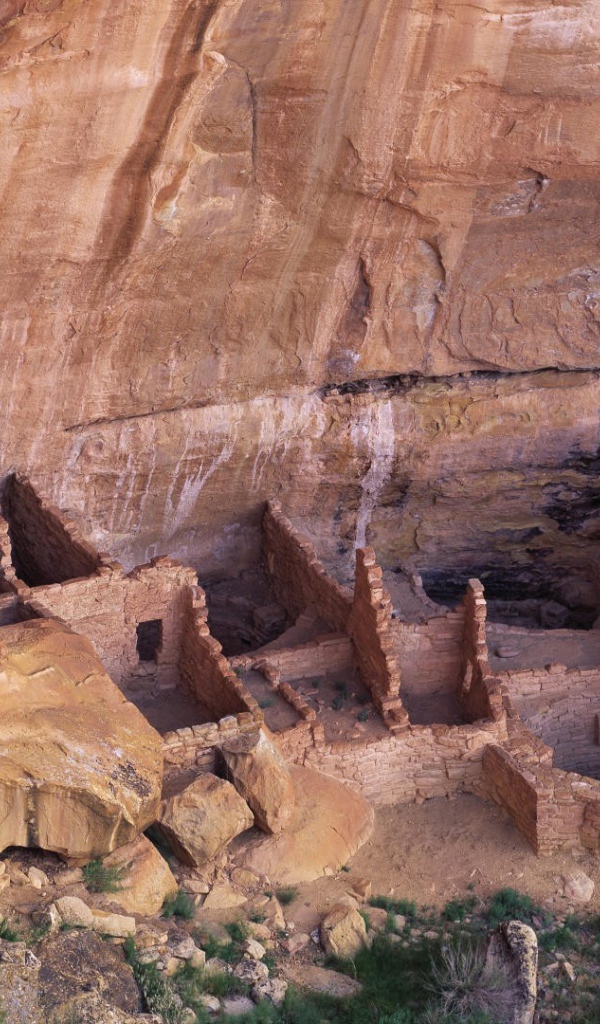 Руины каменных домов под скалой