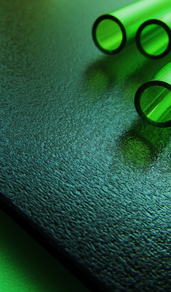 Трубки из зеленого стекла на черной плите