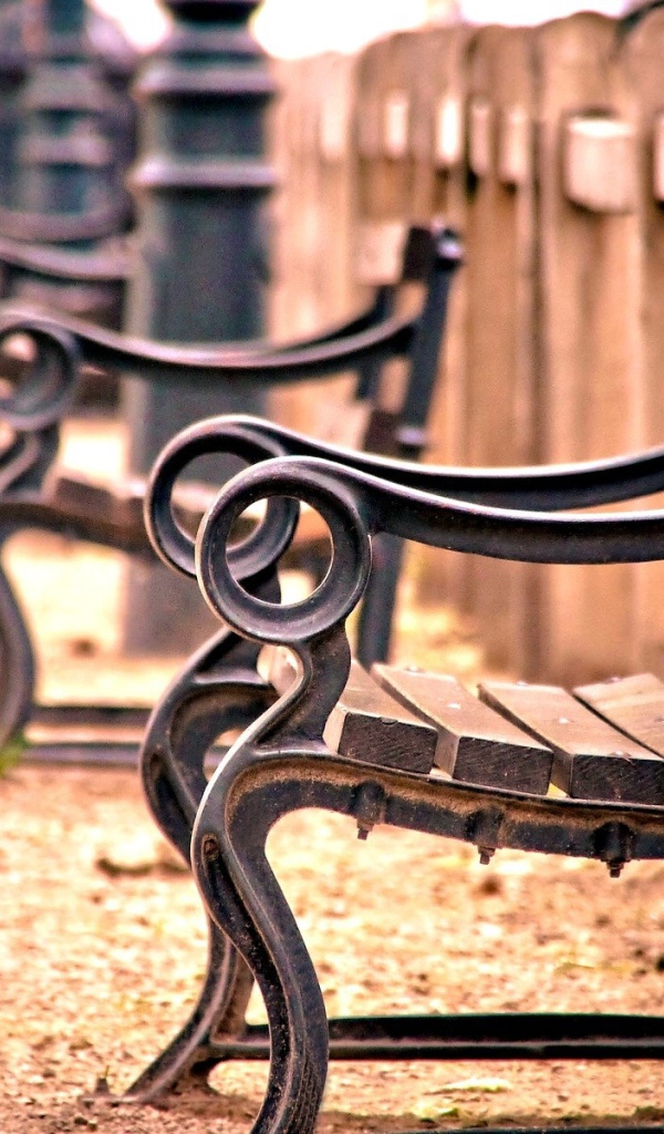 Кованые скамьи у деревянного забора