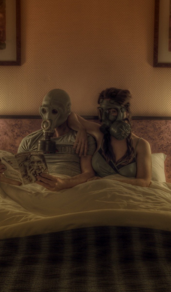 Семейная пара лежит в кровати в масках