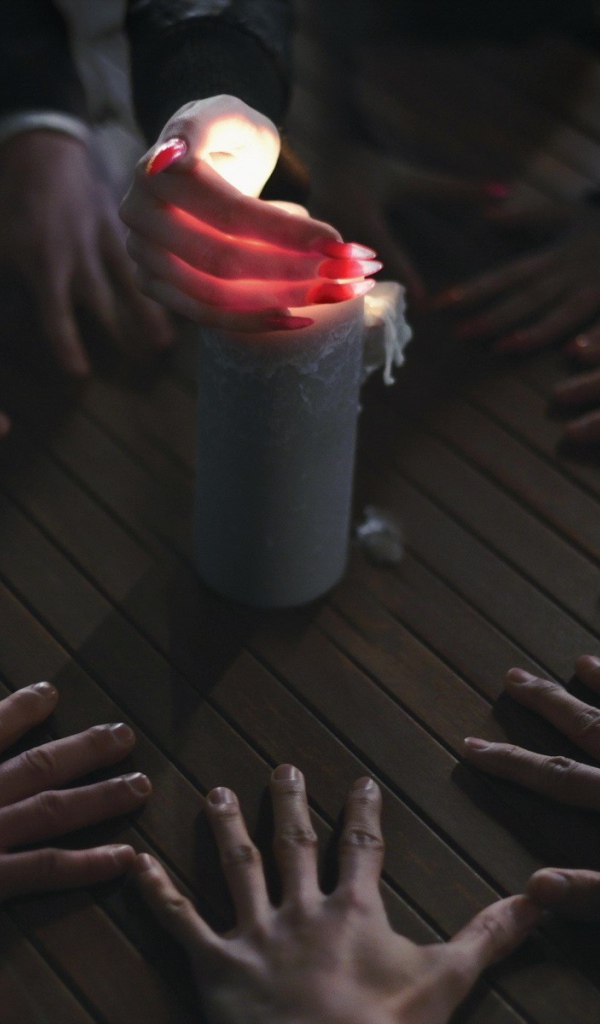 Люди вызывают духа при помощи свечи