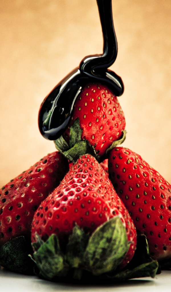 Шоколад льется на клубнику