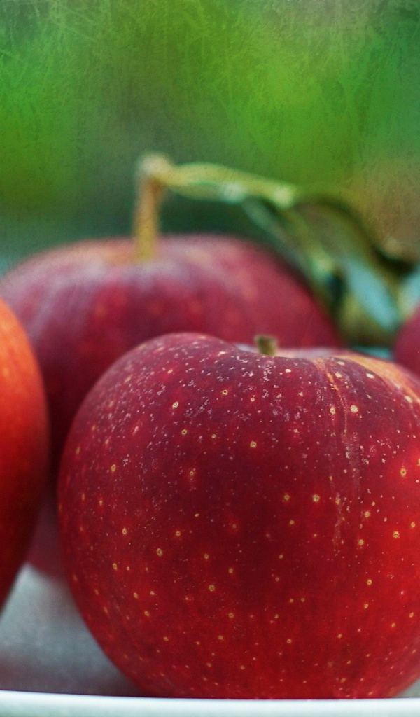 Четыре красных яблока на тарелке