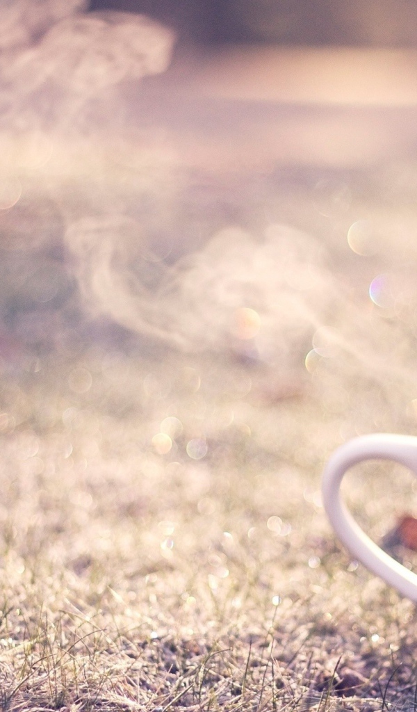 Дымящаяся чашка на траве