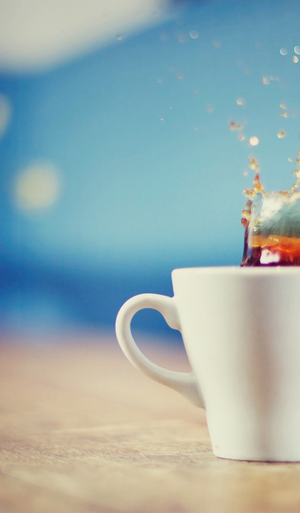 Чай расплескался из белой чашки