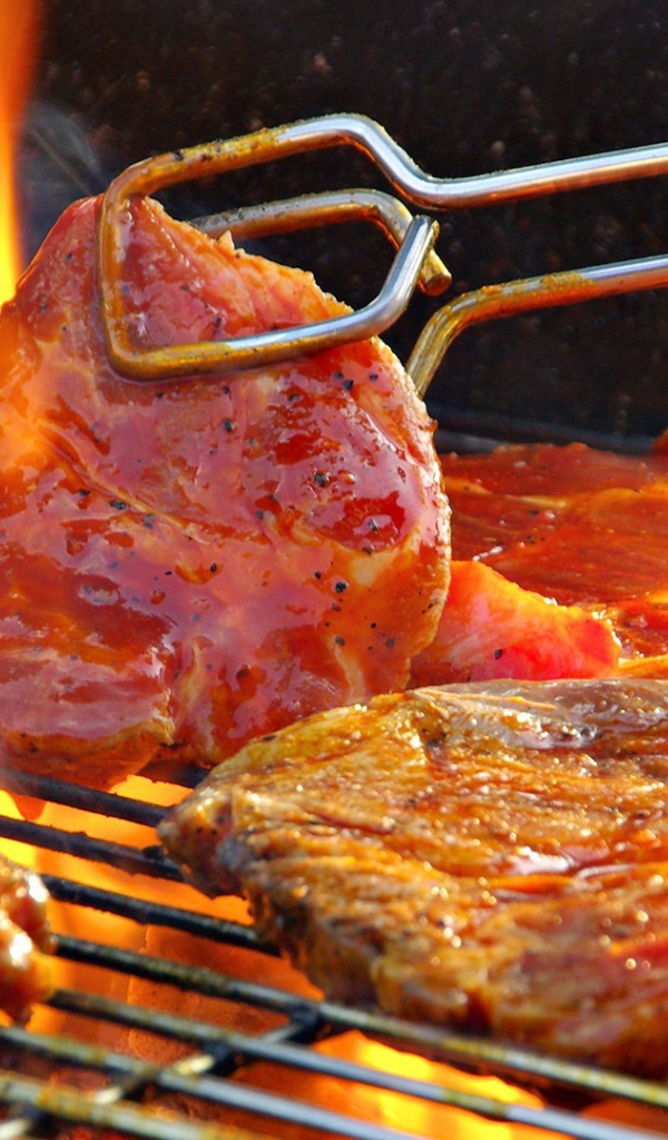 Стейк жарится на огне барбекю