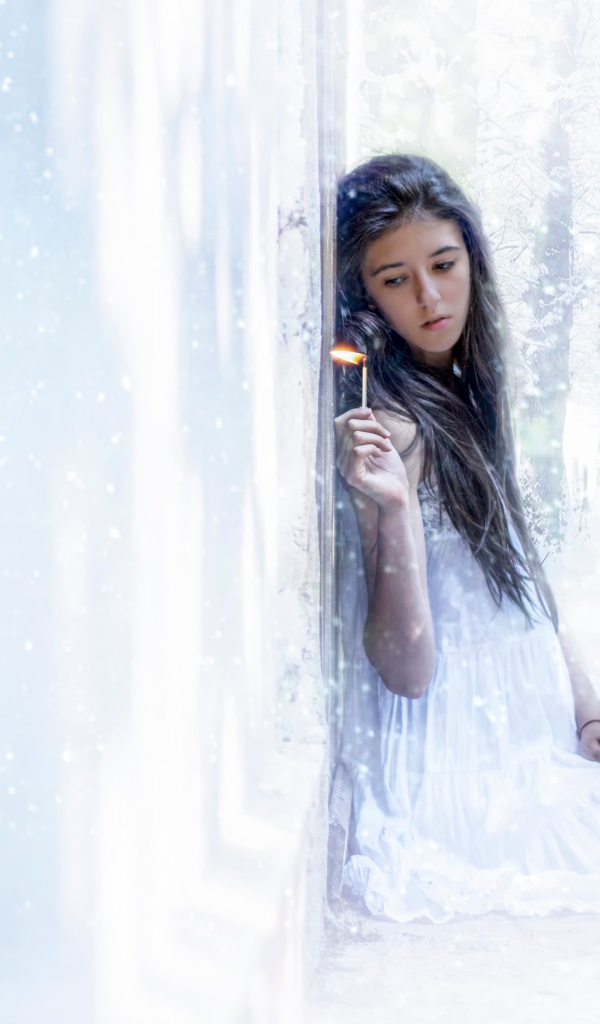 Девушка держит в руке горящую спичку