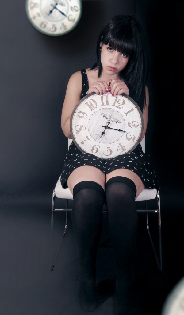 Девушка держит в руках часы