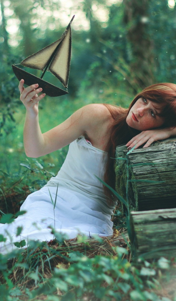 Девушка в белом платье держит в руке кораблик