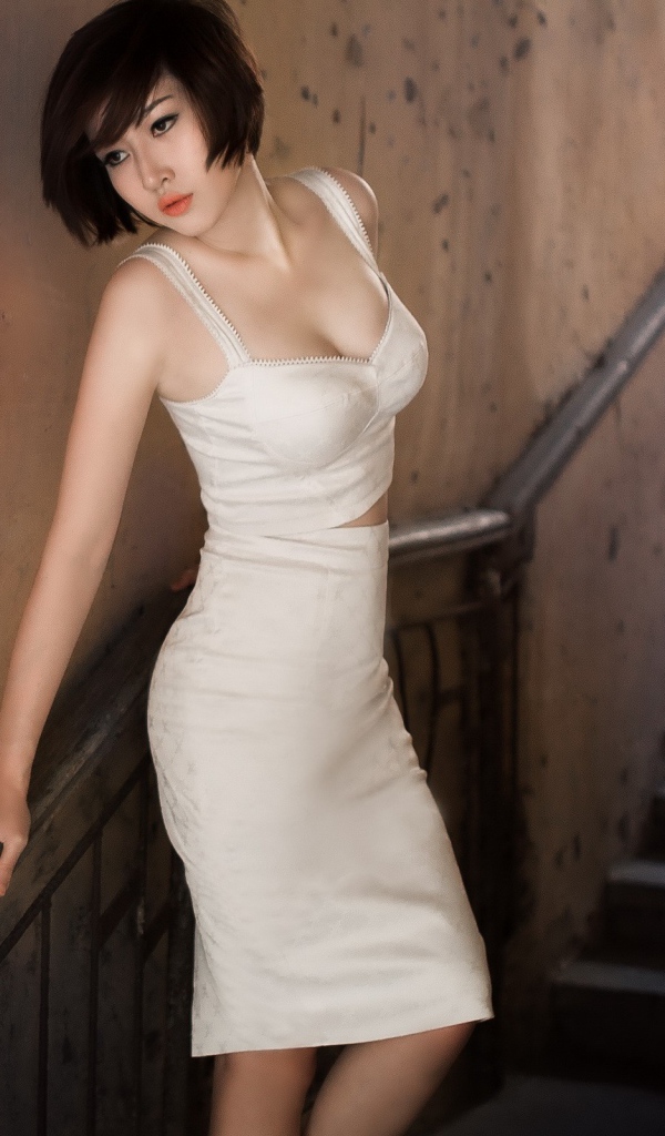 A girl in a white dress on the stairs in the transition