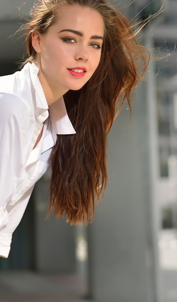 Девушка стоит у вентилятора