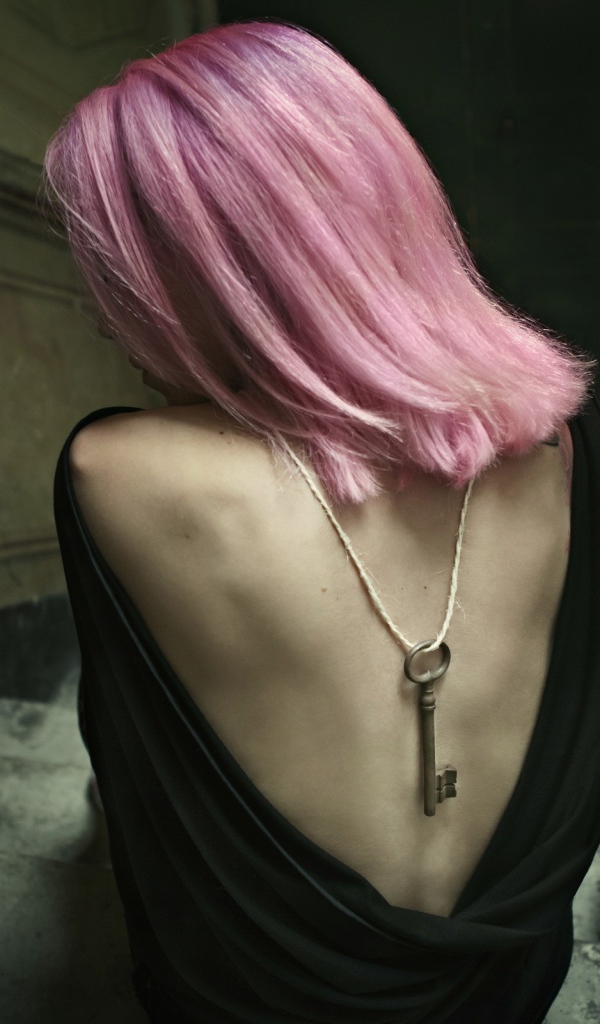 Девушка с розовыми волосами сидит на лестнице