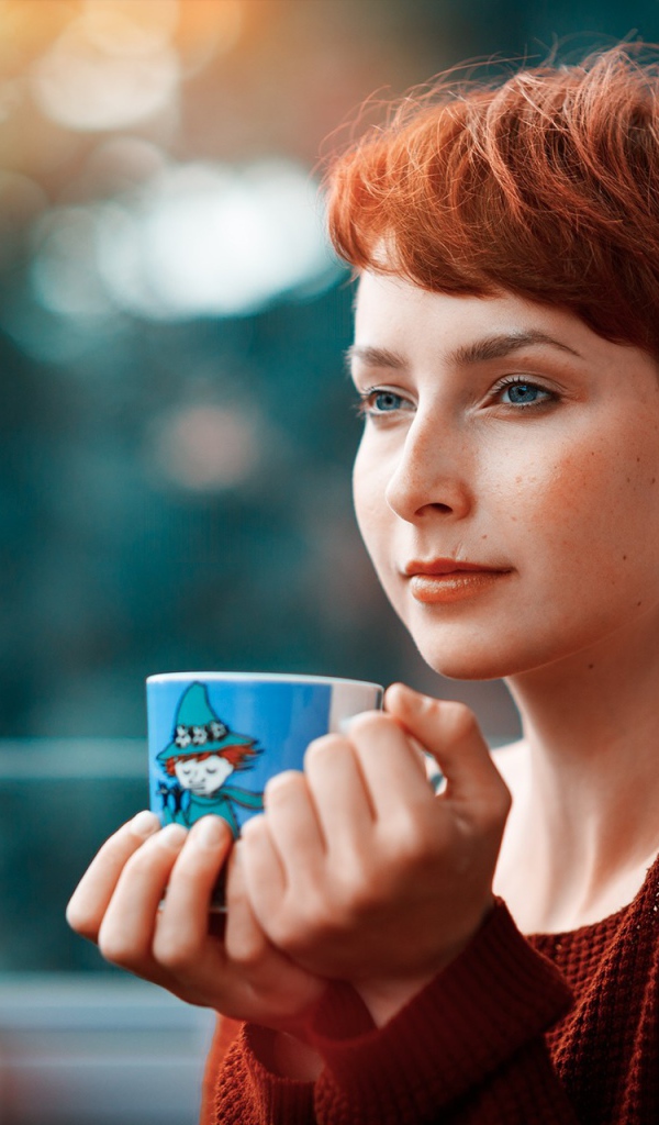 Девушка с короткими волосами пьет кофе