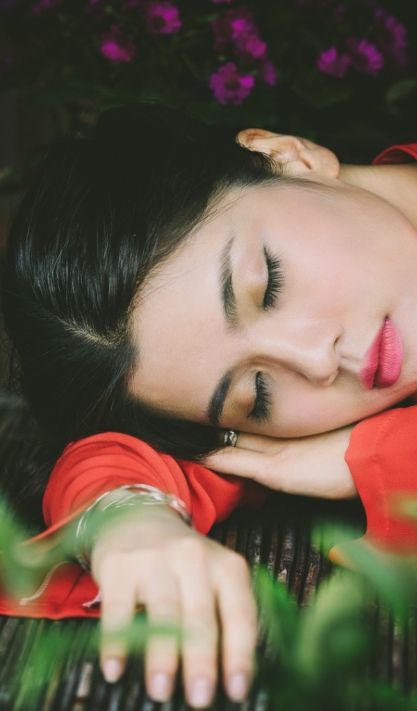 Азиатка спит положив голову на руки