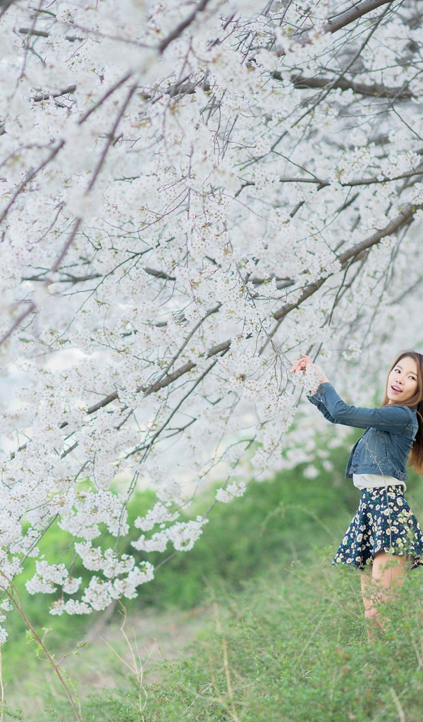 Азиатская девушка радуется весенним цветам