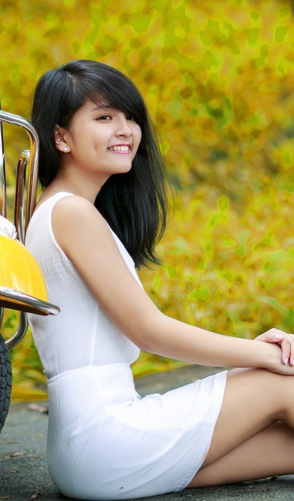 Азиатская девушка у желтого мотороллера