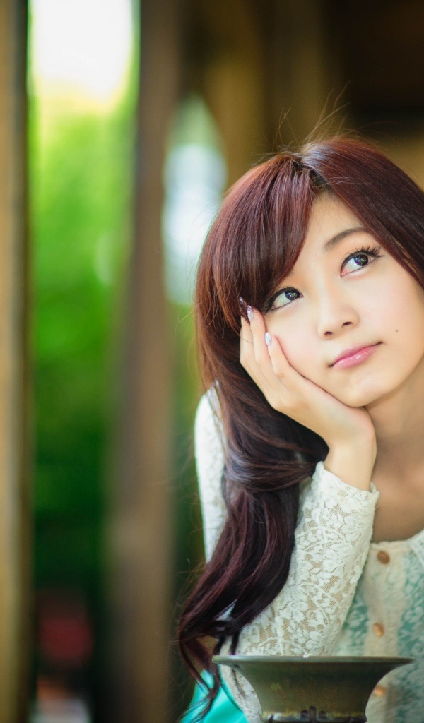 Азиатская девушка задумчиво смотрит вверх