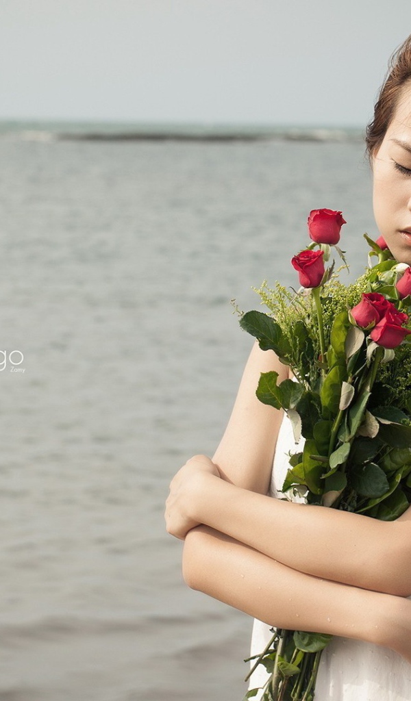 Азиатка держит в руках букет роз