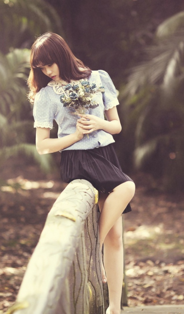 Азиатка с букетом на поручне моста