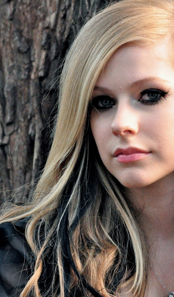 Блондинка Аврил Лавин на фоне коры дерева