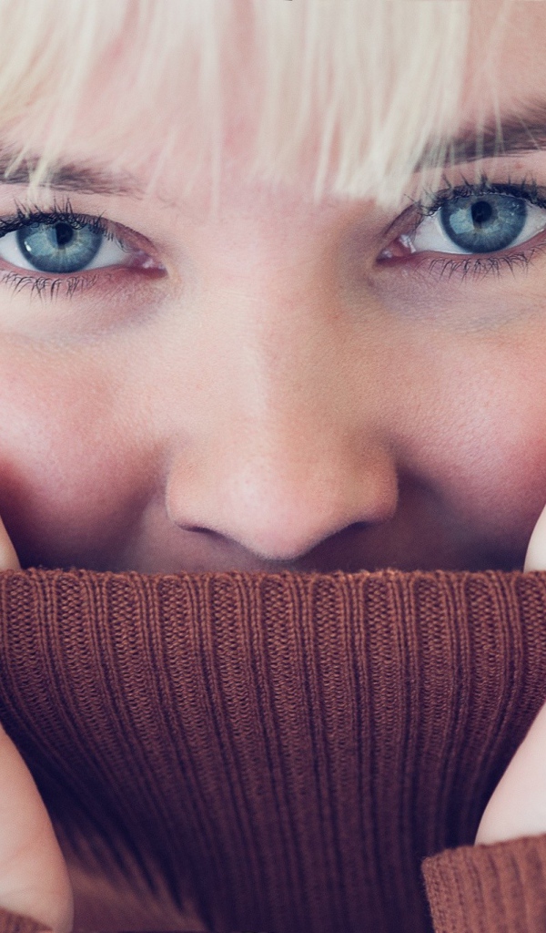 Блондинка прячет лицо в вороте свитера