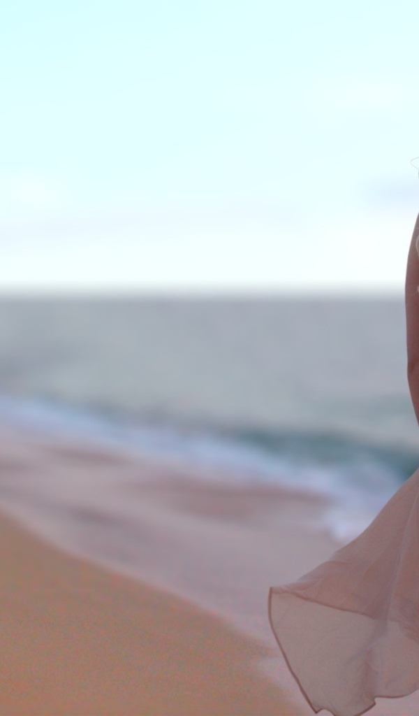 Блондинка в легком платье на пляже