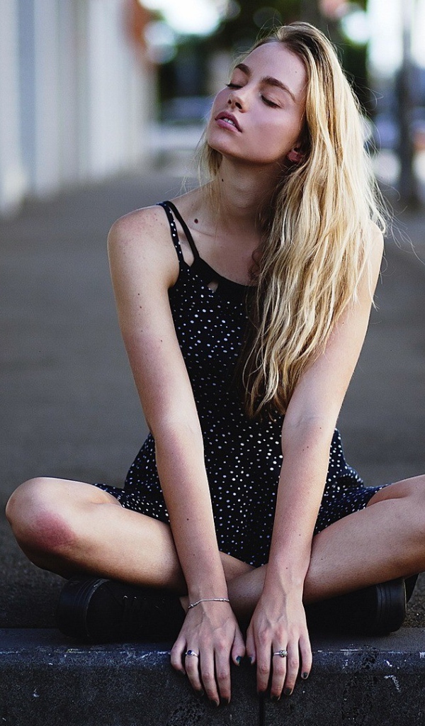 Блондинка медитирует на асфальте