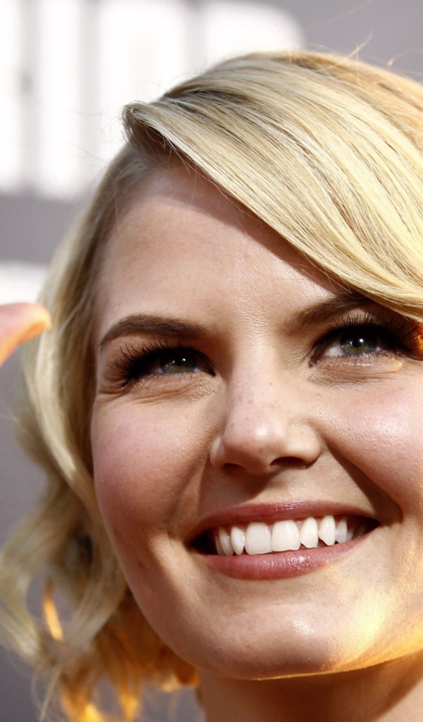 Блондинка улыбается и машет