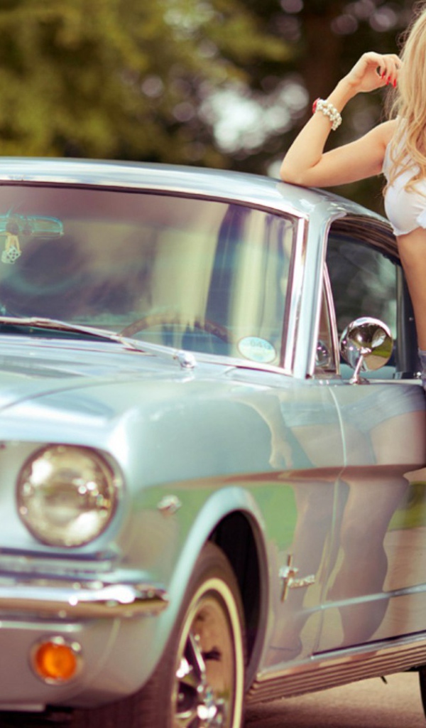 Блондинка стоит у ретро автомобиля