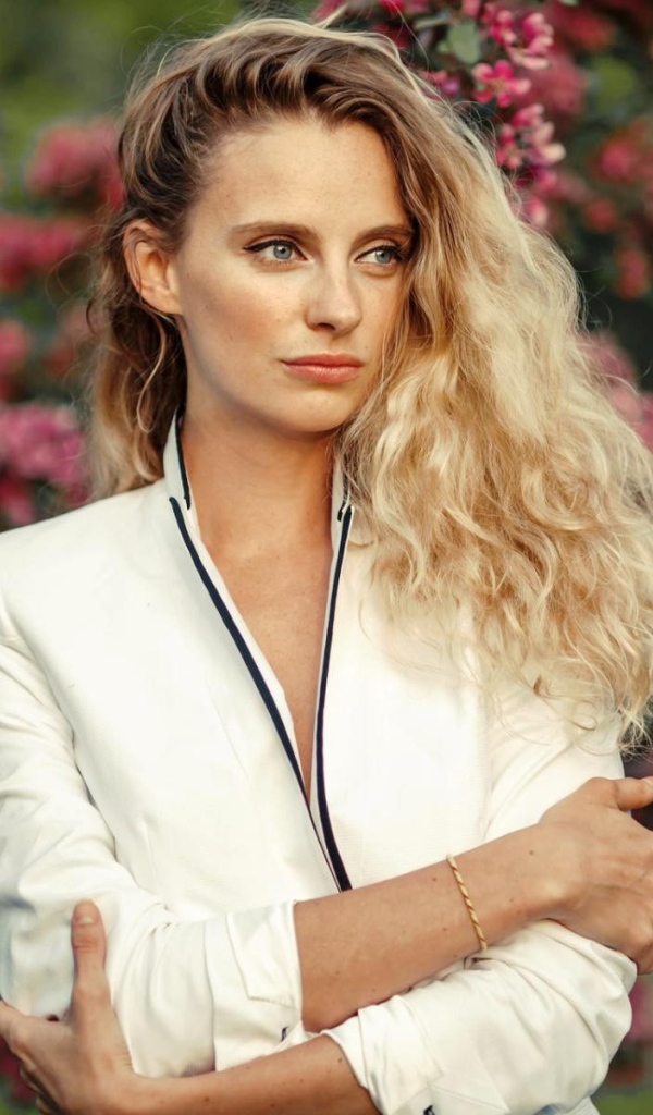 Голубоглазая блондинка на фоне цветущих деревьев