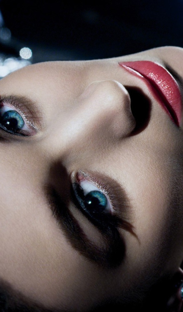 Голубоглазая брюнетка лежит в черном платье