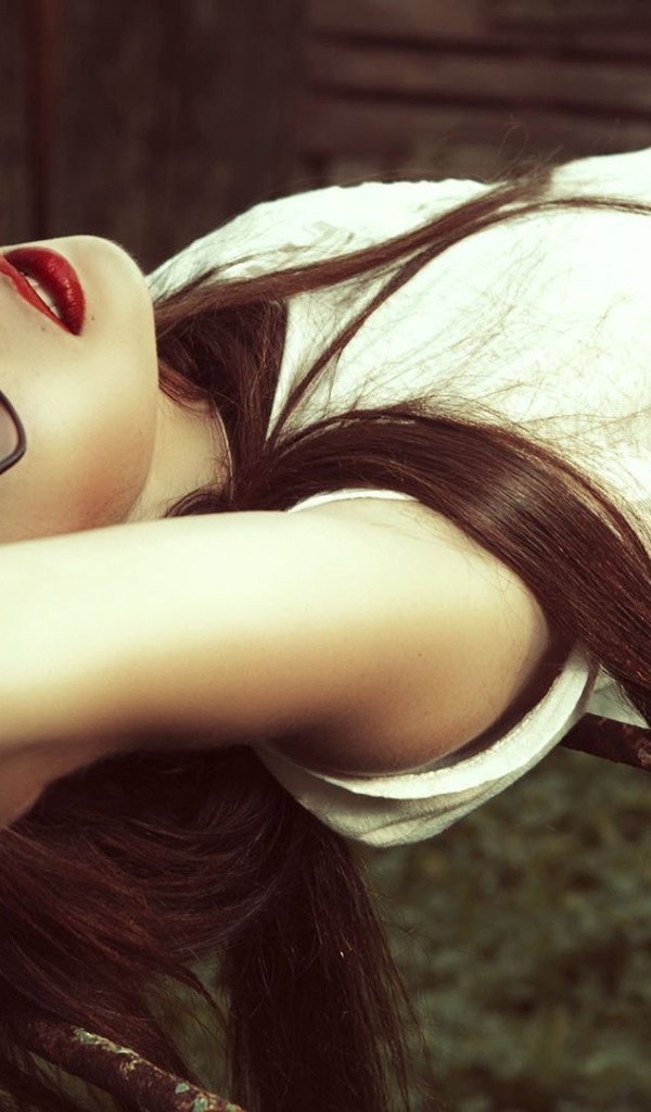 Брюнетка в темных очках смотрит в небо