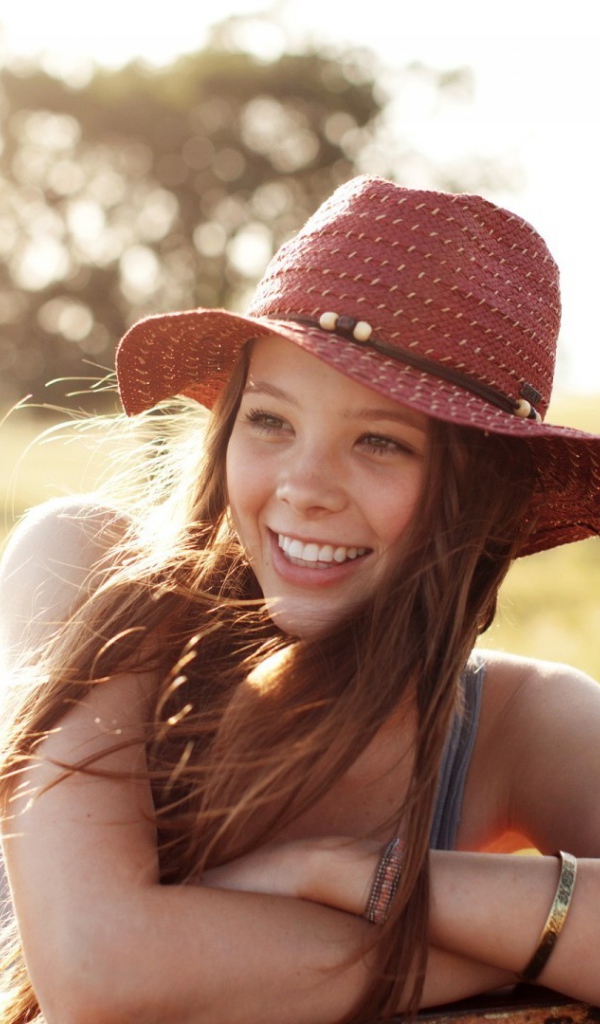 Веселая девушка в легкой красной шляпе