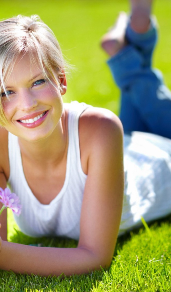 Милая блондинка на нежно зеленом газоне