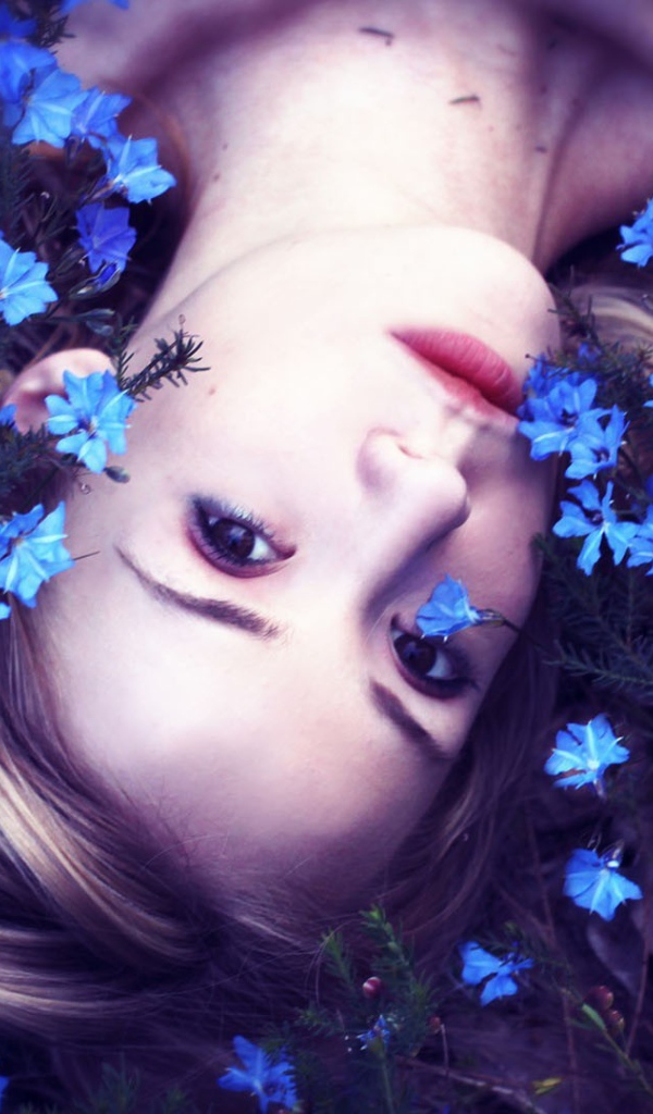 Девушка среди маленьких голубых цветов