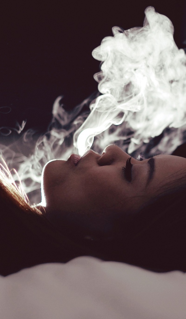 Девушка выпускает дым изо рта