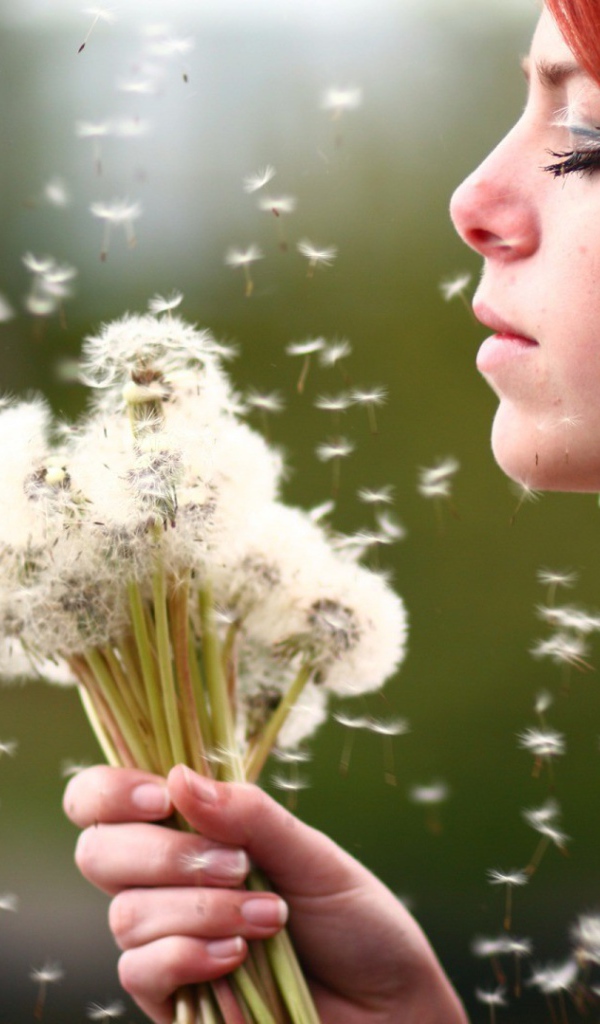 Девушка держит в руках букет одуванчиков