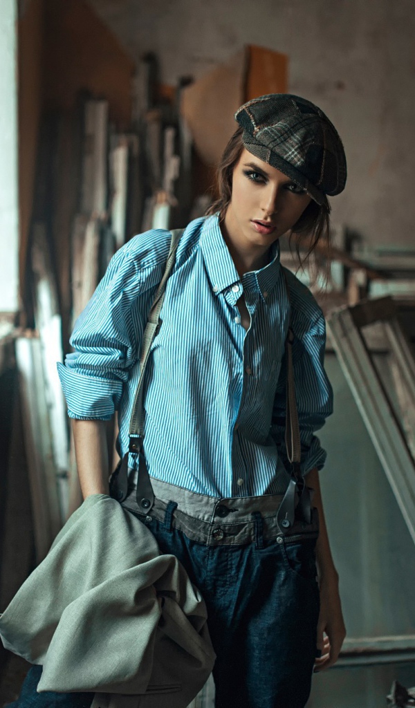 Девушка в берете стоит среди ремонта