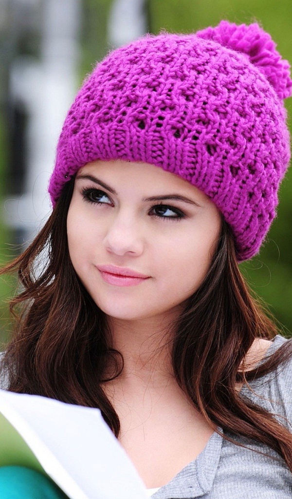 Девушка в сиреневой шапке читает книгу