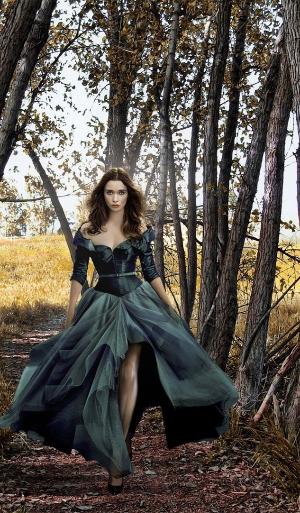 Девушка в черном платье среди деревьев