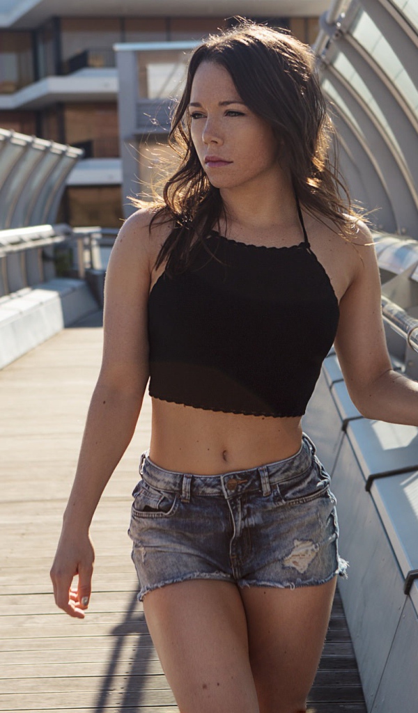 Девушка в джинсовых шортах на мосту