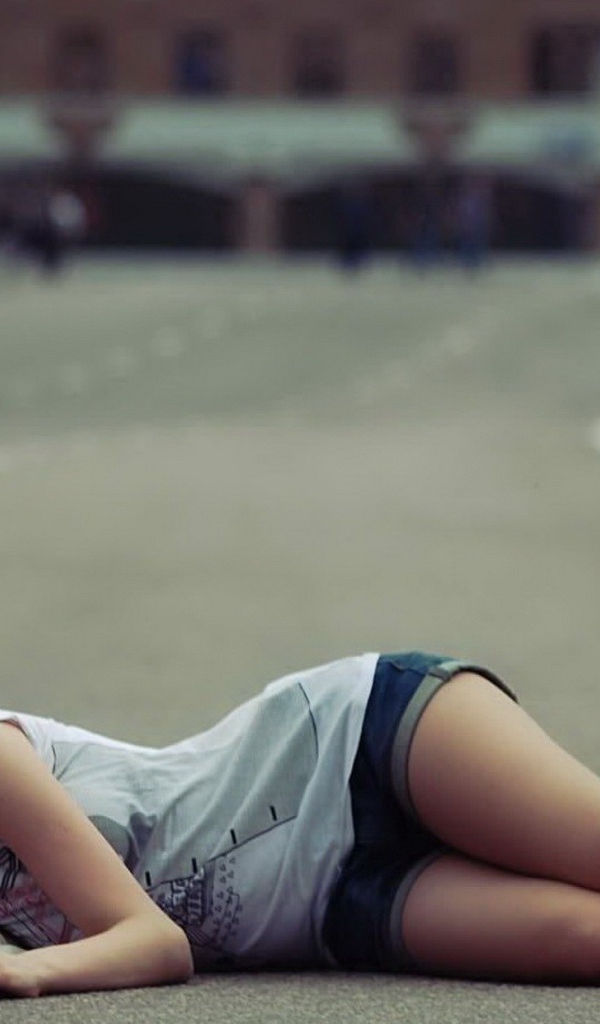 Девушка в шляпе лежит на дороге