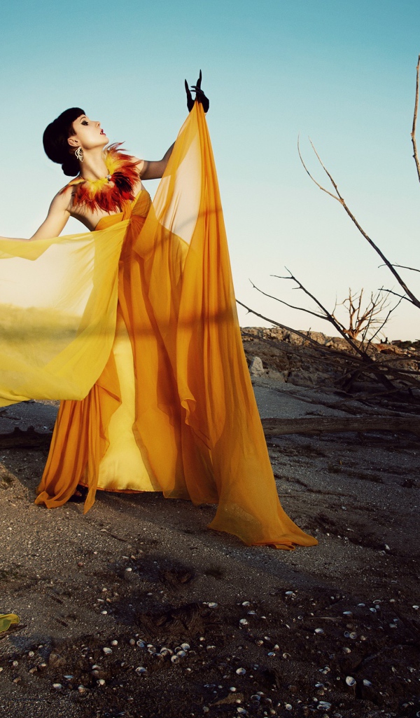 Девушка в оранжевом позирует в пустыне