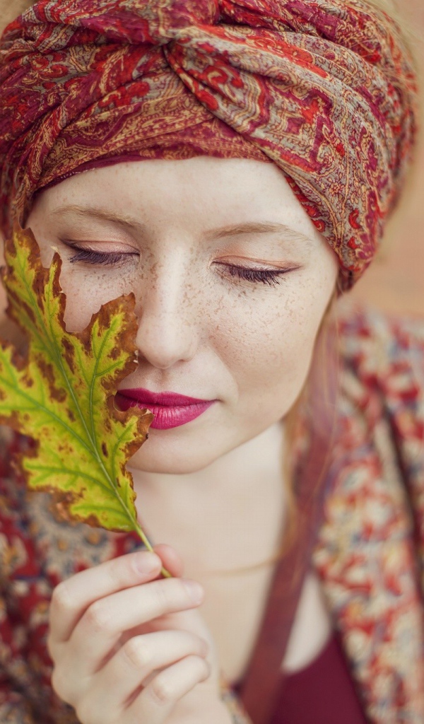 Девушка в традиционном наряде держит в руке лист