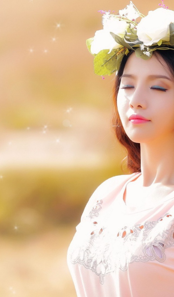 Девушка в белом венке прикрыла глаза