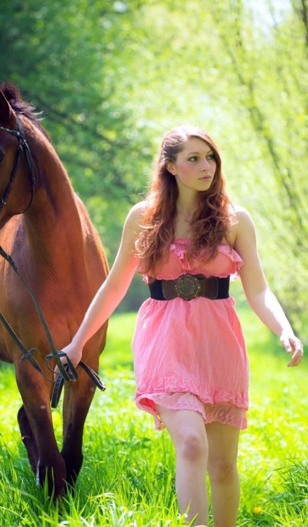 Девушка ведет лошадь под уздцы