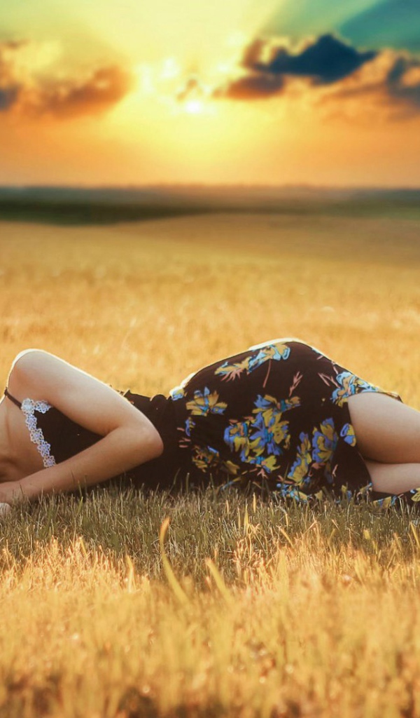 Girl lies on a sloping field