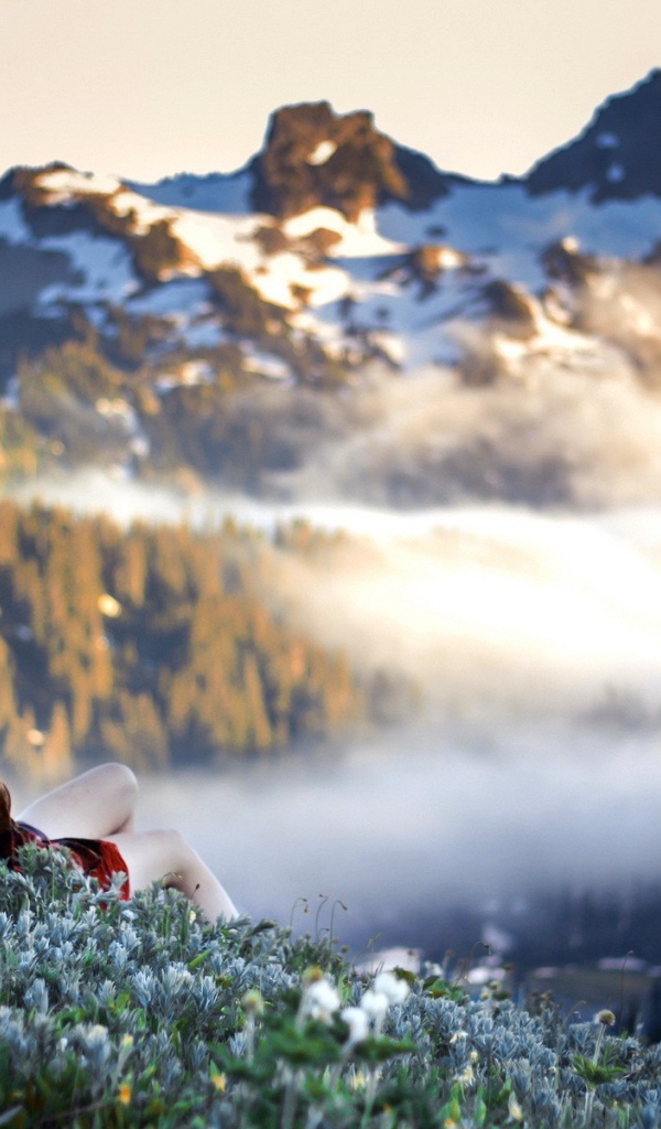 Девушка лежит и смотрит на горы